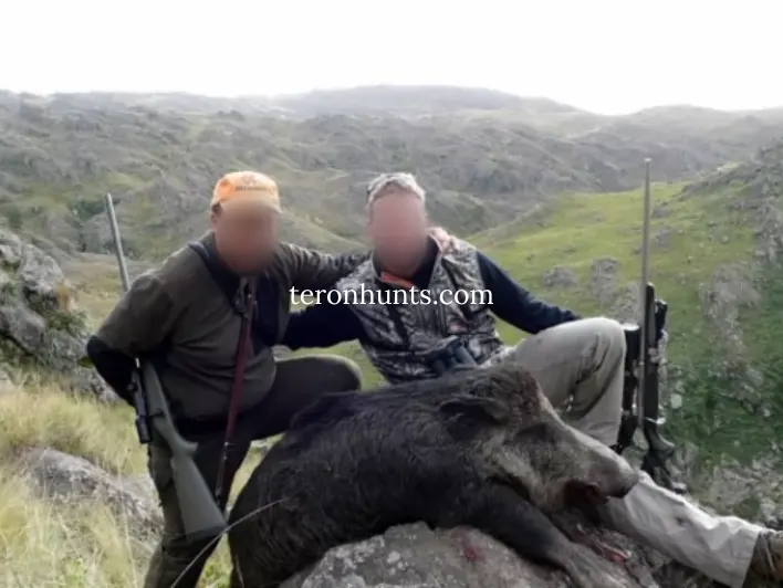 Hunter taking picture with his hunted wild boar in Argentina, example of successful client of Teron who went wild boar hunting in Argentina