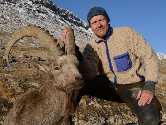 Hunter taking picture with his hunted ibex in Kyrgyzstan, example of successful client of Teron who went ibex hunting in Kyrgyzstan