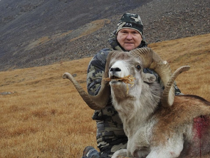 Hunter taking picture with his hunted Marco Polo sheep in Kyrgyzstan, example of successful client of Teron who went Marco Polo sheep hunting in Kyrgyzstan